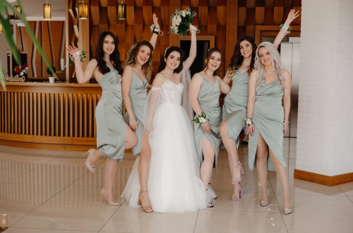 A bride and her bridal party wearing midi dresses