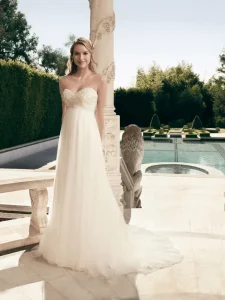 Woman posing in front of pool with wedding gown