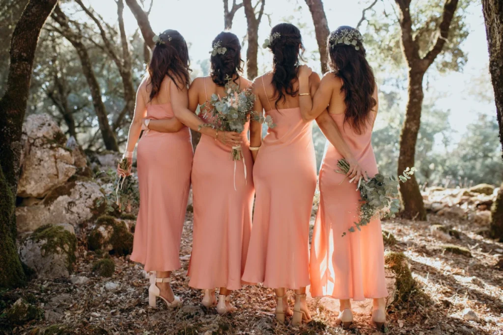 Four bridesmaids in coral colored crepe dresses