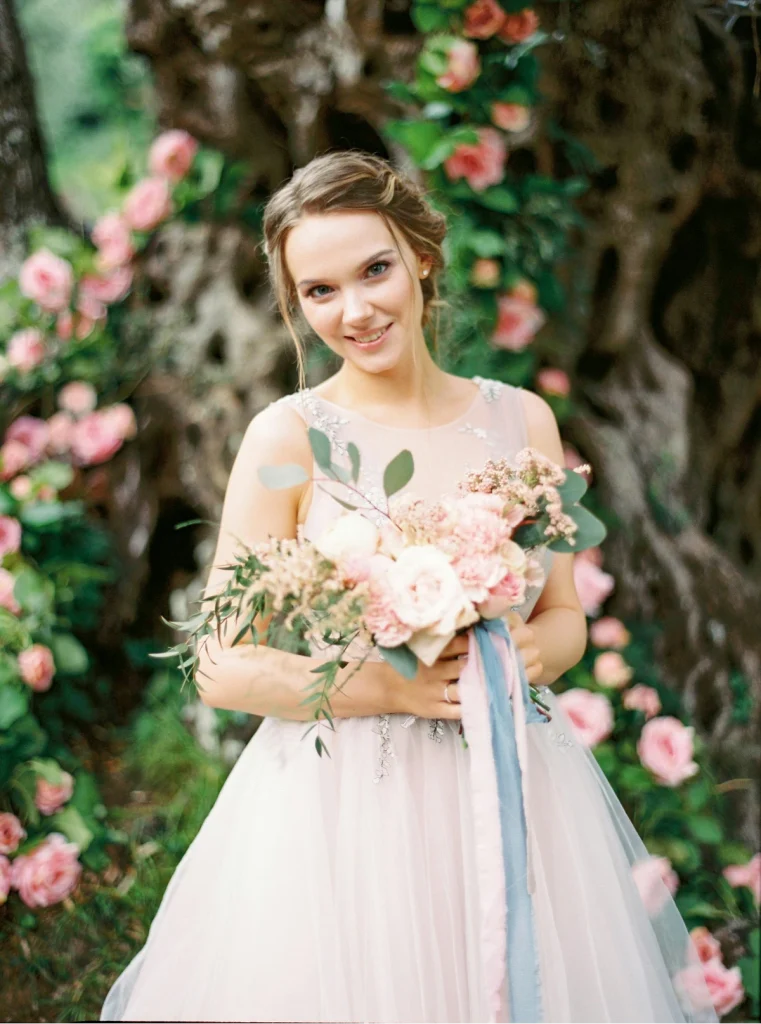 Smiling woman holding a bouquet with a tulle dress on