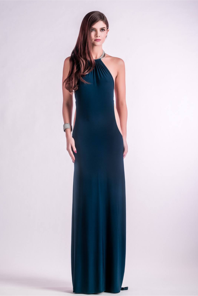 Bridesmaid in a sleek navy gown posing in front of a white backdrop.