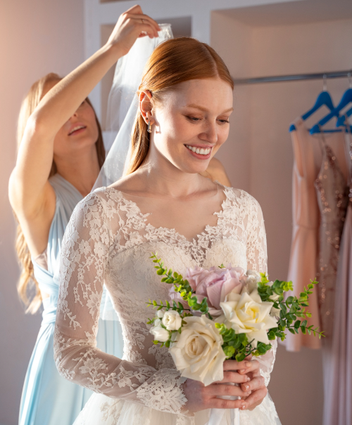 Bride holding flowers while dressing.